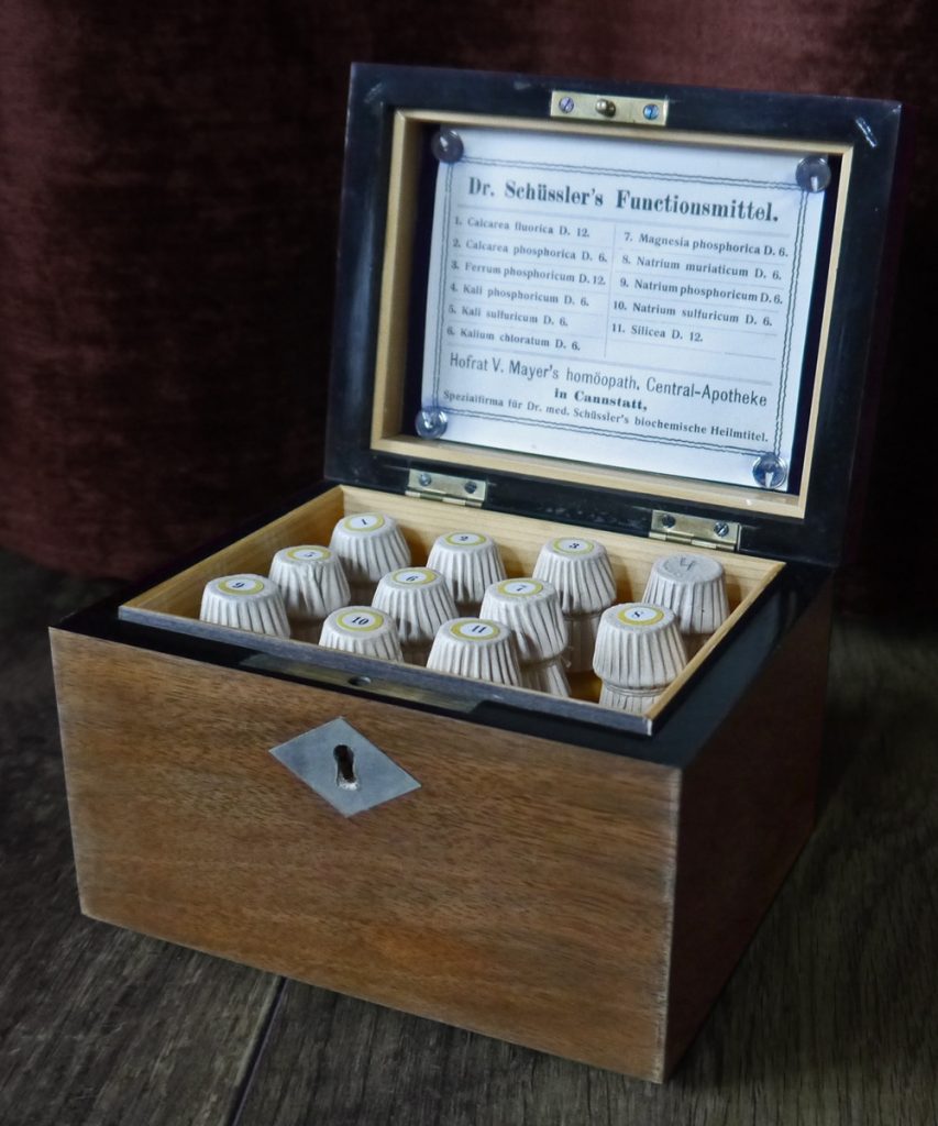 Bild: Kiste mit 11 Schüssler-Salzen von 1923 von DeepSilent63 – Eigenes Werk [CC BY-SA 4.0], via Wikimedia Commons